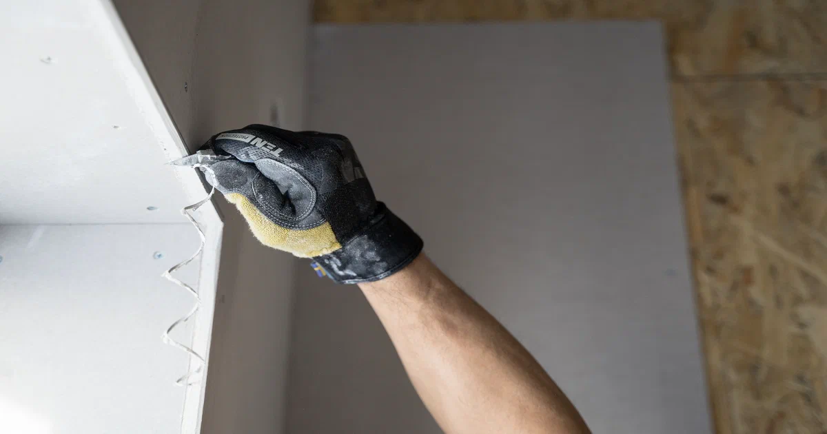 Tireur de joint professionnel appliquant du composé sur un mur de gypse au Québec